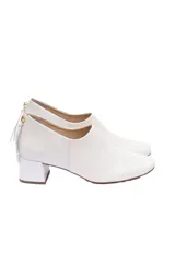 Zapato color blanco hueso con punta cuadrada, confeccionado en cuero nobuck y napa. Presenta un diseño con textura de piel de serpiente en la parte trasera, cierre de cremallera dorado en el talón con tirador de cuero, y un taco forrado de 5 cm.