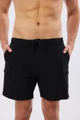 Short de baño cargo color negro, de diseño liso con bolsillos laterales y bolsillos utilitarios con solapa y botón en las piernas. Cuenta con cintura elástica ajustable mediante cordón.