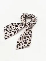 Colero para el pelo con diseño de scrunchie y lazos colgantes, estampado con motivo animal print en tonos beige y negro.