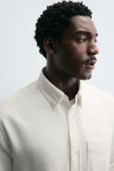 Camisa de corte relajado confeccionada en algodón, con cuello solapa, manga larga con puños abotonados, bolsillo de plastrón en el pecho y cierre frontal con botones.