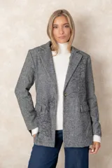 Blazer de corte sastre con diseño de espiga en tonos grises. Presenta un bordado floral lineal en el lateral, solapas clásicas, cierre frontal con un botón y bolsillos con solapa.