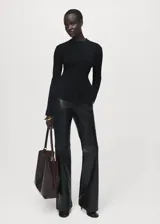 Jersey negro de punto de canalé con cuello caja, manga larga y corte peplum acampanado en la cintura.