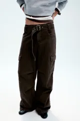 Pantalón cargo de tiro medio confeccionado en denim negro con efecto lavado. Presenta bolsillos laterales con solapa, bolsillos delanteros y traseros, corte recto y cinturón del mismo tejido incluido con hebilla metálica.