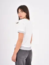 Remera de algodón en color negro con detalles en blanco en el cuello, mangas y ruedo. Presenta un diseño de estilo ringer con terminaciones acanaladas.