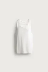 Camiseta sin mangas tipo tank top de corte slim fit, confeccionada en tejido de algodón con elasticidad, cuello redondo amplio y vivos en tejido combinado a tono.