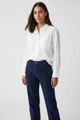 Camisa de manga larga color celeste, con cuello clásico, cierre frontal con botones y un bolsillo aplicado en el pecho.