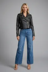 Campera estilo motoquera de símil cuero negro, con solapas amplias y detalles de tachas metálicas en solapas, hombros y mangas. Presenta cierre frontal cruzado, bolsillos con cierre y trabillas en el ruedo.