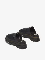 Sandalia negra de cuero con plataforma Mattison, suela híbrida de EVA y PVC con dibujo dentado, ranurado característico de Dr. Martens y costura amarilla. Cuenta con plantilla de espuma cubierta en gamuza y correa ajustable con hebilla.