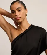 Blusa negra de crepé con drapeado lateral y hombro único.