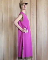 Vestido largo de punto sin mangas, color fucsia con una estrella blanca grande estampada en la espalda. Presenta detalles en color marrón en el cuello, las sisas y el ruedo, además de tajos laterales en la parte inferior.