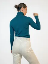 Polera de cuello alto en color azul, de manga larga con puños ajustados y tejido de punto fino.