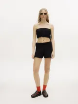 Top strapless tipo crochet color negro, de diseño tejido con detalles en ochos y puntos calados, con espalda descubierta y tiras ajustables en el lateral.