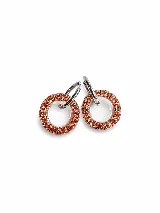 Dijes colgantes circulares de resina con incrustaciones de strass y aro superior de acero, con un diámetro aproximado de 2 cm.