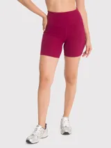 Calza corta deportiva de tiro alto, color bordó, con bolsillos laterales y banda de silicona para mayor sujeción.