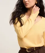 Suéter de punto color amarillo, con escote en V y mangas largas. Presenta un diseño básico y versátil, confeccionado en una mezcla de viscosa, poliamida y elastano.