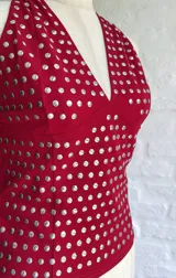 Top halter rojo con escote en V y apliques metálicos plateados.