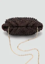 Bolso tipo clutch de tamaño pequeño, color marrón, elaborado en tejido de fibra natural con abalorios de madera incrustados y cierre a presión.