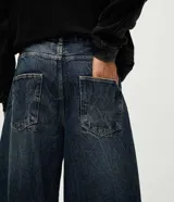 Pantalón de jean con calce barrel, caracterizado por su volumen amplio en las piernas y un sutil ajuste en la botamanga. Presenta costuras desplazadas y un lavado medio, confeccionado en algodón resistente.