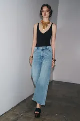 Jeans de tiro alto y corte ancho (wide leg) hasta el tobillo, confeccionados en denim azul de efecto lavado. Presenta cinco bolsillos y cierre frontal con cremallera y botón.