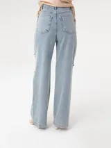 Pantalón de jean celeste de corte ancho, con roturas en las rodillas y apliques de strass.