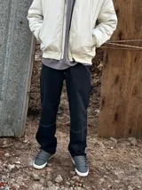 Pantalón de jean negro de corte recto, con bolsillos laterales y traseros, y presilla lateral para herramientas.