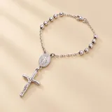 Pulsera tipo denario de plata con cuentas facetadas, medalla de la Virgen y dije de cruz colgante.