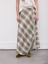 Falda larga de corte cruzado con estampa a cuadros en tonos beige, verde militar y azul oscuro, con detalle de flecos en el borde delantero.
