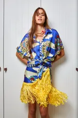 Falda corta tipo pareo con estampado floral y a rayas, con flecos dorados en el ruedo. Se ata a la cintura.