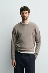 Sweater de punto relaxed fit confeccionado en hilatura con viscosa de tacto suave, color marrón, con cuello redondo y manga larga. Cuenta con acabados en rib.