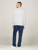 Chomba de manga larga Tommy Hilfiger color gris, confeccionada en algodón. Tiene cuello tipo polo, cartera de dos botones y logo bordado en el pecho.