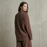 Pantalón de corte holgado y tiro alto, confeccionado en tela de textura rústica, con cintura elástica y diseño fluido.