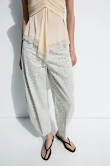 Jeans tiro alto corte tapered de Zara Woman Collection, confeccionados en denim con estampado floral y rayas verticales sutiles. Presenta diseño de cinco bolsillos, trabillas para cinto y cierre frontal con cremallera y botón metálico.