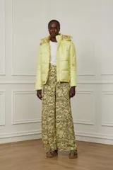 Campera puffer amarilla con estampado abstracto en color borgoña, con capucha y cierre frontal con botones a presión.