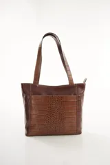 Cartera tipo tote de cuero vacuno negro con doble asa de hombro, panel superior liso y bolsillo exterior frontal con textura símil cocodrilo y costuras visibles en contraste.