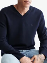 Sweater de punto liso color azul marino, con cuello en V y manga larga. Presenta un pequeño monograma bordado en el pecho.