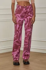 Pantalón jean de corte recto con estampado abstracto en tonos rosa y bordó.