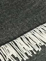 Bufanda de estilo clásico en color beige, confeccionada en tejido suave y cálido, con detalle de flecos en los extremos.