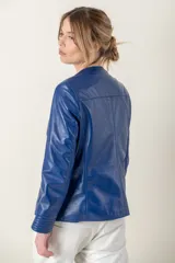 Campera de cuero ovino italiano color verde azulado, con cuello mao, cierre frontal con broches ocultos, bolsillos laterales y detalle de capitoneado en puños y bolsillos.