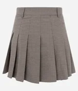 Short pollera de sastrería color marrón con estampa a cuadros, diseño plisado y cintura con pasadores. Combina la comodidad de un short con la estética de una minifalda.