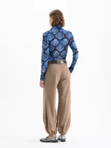 Pantalón Victoria gris confeccionado en lanilla con fit amplio y cómodo. Cuenta con bolsillos ocultos en el delantero y bolsillos ojal en la parte trasera. Presenta presillas y ajuste en los tobillos mediante elástico, que aporta una silueta relajada y caída.