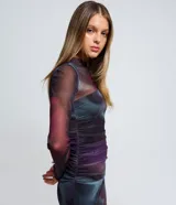 Vestido midi de tul con diseño ajustado, mangas largas y detalles fruncidos en el frente. Presenta un estampado con efecto manchado en tonos oscuros y una abertura lateral en la falda.