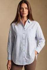 Camisa oversize de manga larga con patrón de rayas verticales celestes y blancas, cuello camisero, bolsillo aplicado en el pecho y cierre frontal con botones.