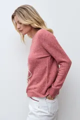 Sweater de punto color rojo melange, con cuello redondo, manga larga y detalle de bordado floral en relieve en color crudo en el frente.