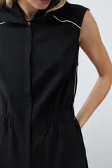 Mono negro de lino con corte recto, cuello camisero, sin mangas y vivo blanco en contraste en cuello, sisas y laterales.