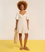 Vestido corto evasé color celeste, con escote en V, mangas cortas amplias, recorte cutout en los laterales de la cintura y volado en el bajo.