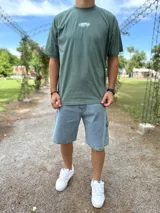Remera oversize verde militar con estampado gráfico en la espalda con el texto "TOPSTYLE COLLECTIONS EST 2021".