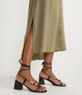 Vestido chemise largo color naranja, confeccionado en viscolino. Tiene cuello solapa, cierre con botones, manga larga con martingale, aberturas laterales y no tiene estampado.