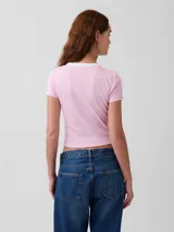 Remera corta de ajuste ceñido color blanco con cuello redondo y ribete negro. Presenta mangas cortas y el logo bordado de Gap en el pecho.