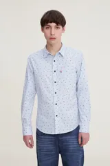 Camisa de manga larga Levi's con estampado de pequeños motivos geométricos en color azul claro. Presenta cuello clásico, cierre frontal con botones, puños abotonados y un bolsillo en el pecho con la etiqueta roja característica de la marca.
