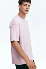 Remera de punto de algodón de peso medio en color lila, con cuello redondo ribeteado, hombros caídos y bajo recto. Diseño de corte relajado y silueta casual.